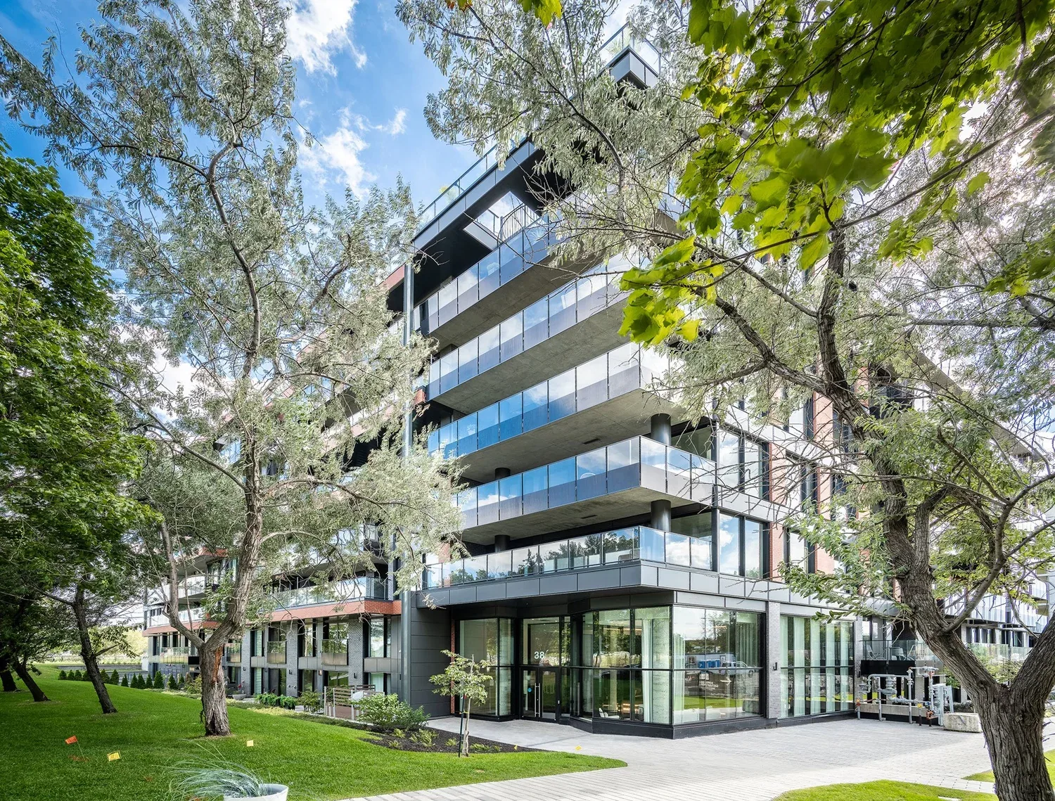 Galdin condominium exterior in Montréal, with glass balconies and mature trees